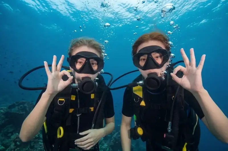 Expert dive buddy guides assisting local scuba divers with Fairyland Resort in the Celebes Sea.