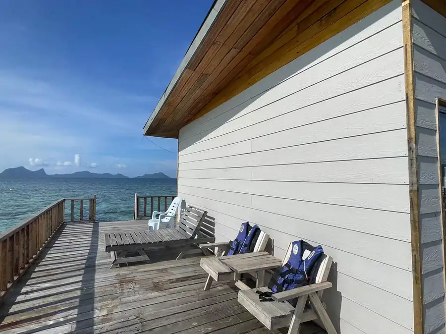 Expansive private outdoor deck with sea views at Fairyland Resort. This barefoot luxury retreat offers wooden loungers and a gentle sea breeze with views of Tun Sakaran Marine Park islands.